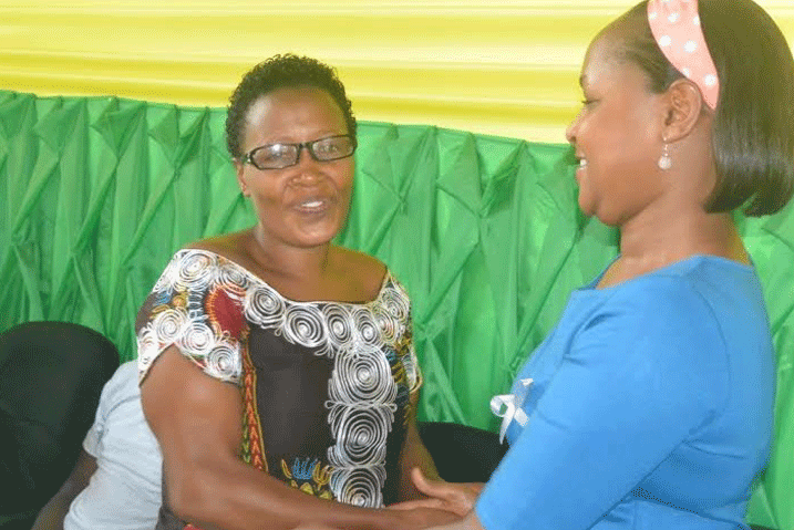 Mbabazi (iburyo) ashyikiriza inkunga uhagararaiye Koperative COCOUNYA