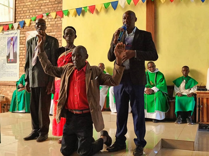 Jean Bosco Habarurema ufite (micro) ubwo yatangaga ubuhamya, na Barambanza (upfukamye) asaba imbabazi mu ruhame