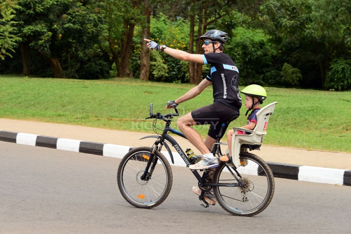 Iyi foto yafatiawe muri Car Free Day iragaragaza Umubyeyi utwaye umwana we ku igare bari muri siporo