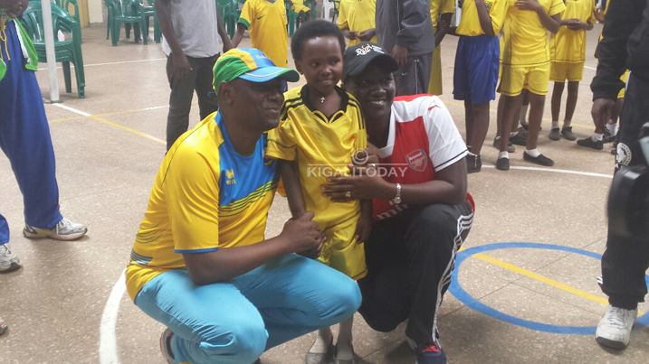 Minisitiri w'umuco n'Umunyamabanga wa Leta ushinzwe amashuri abanza n'ayisumbuye bifotoranya n'umwana muto wiga mu mwaka wa 6 w'amashuri abanza