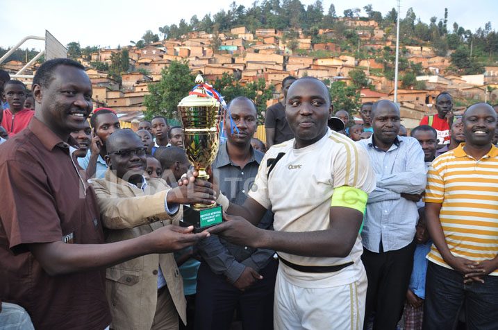 Mukimbili P.Claver.kapiteni wa APR ashyikirizwa igikombe na Robert Bayigamba