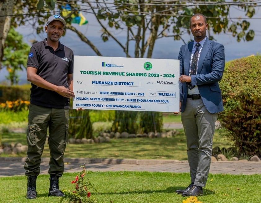 Umuyobozi wa Pariki y'Ibirunga, Uwingeri Prosper (ibumoso) ashyikiriza sheki uwari uhagarariye Akarere ka Musanze