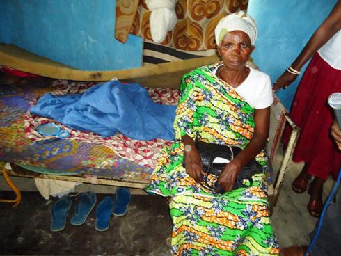 Adelina Mukagakara, yicaye ku buriri aryamaho.