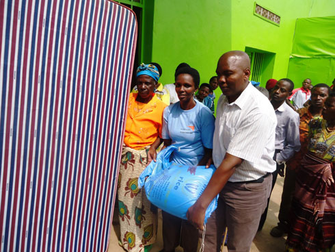 Abakozi ba World Vision bashykiriza inkunga umwe mubacitse ku icumu. (Foto:L.Nshimiyimana)