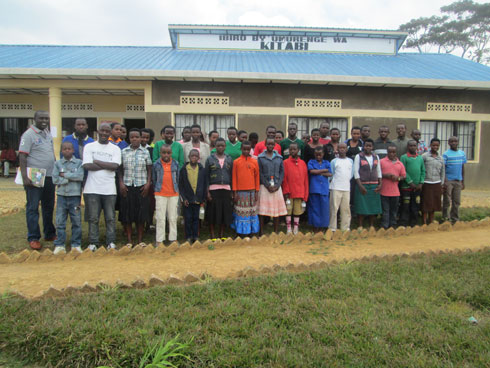 Abana bahagarariye abandi na Habinshuti Vedaste, umukozi wa World vision bafata ifoto y