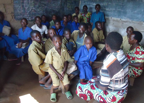 Abanyeshuri bicara ku ntebe z'imbaho bikabagora kwandika.