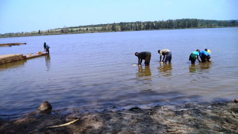 Abaturage bavoma amazi mu kiyaga cya Kidogo gikunze kubamo ingona nyinshi.