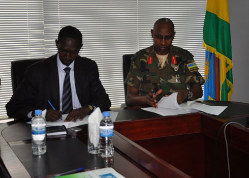 Abayobozi bombi bashyira umukono ku masezerano.