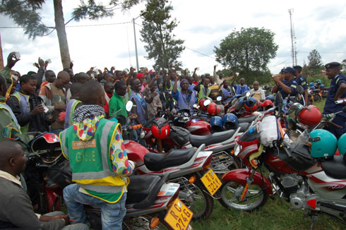 Aha abamotari bitabiriye inama barerekana impushya zabo zo gutwara ibinyabiziga.