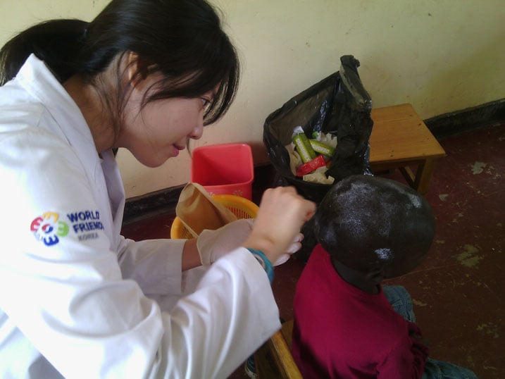 Aha umwe mu bakorerabushake yasigaga umuti mu mutwe w'umwana.