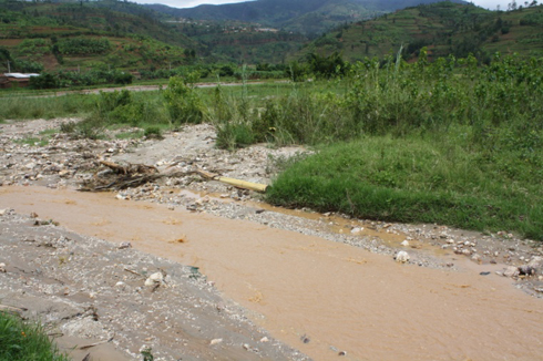 Amazi aturuka muri GMC aracyanyura mu murima w'amagweja.