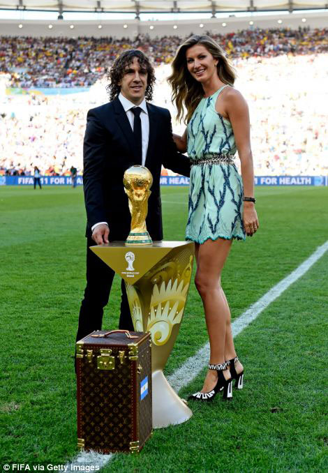 And Gisele, icyamamare muri Brazil mu kwerekana imideri ari kumwe na Carles Puyol, wahoze akinira Espagne yanatwaye igikombe cyaherukaga kubera muri Afurika y'Epfo nibo bazanya igikombe ku kibuga.