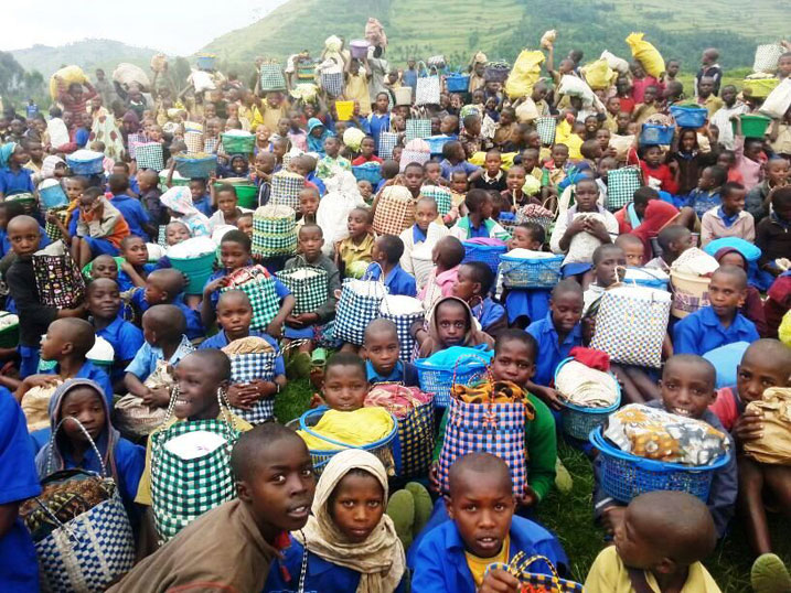 Buri mwana yari afite akantu karimo icyo yagennye gufashisha bagenzi be kandi akeye ku maso yishimiye gufasha.