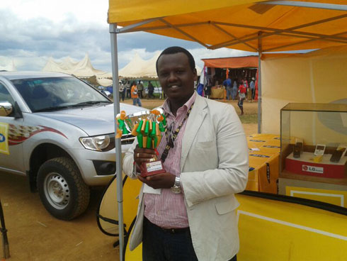 Rudahunga Tigana uhagarariye MTN mu burasirazuba yerekana igikombe iyi sosiyete yegukanye mu imurikagurisha.