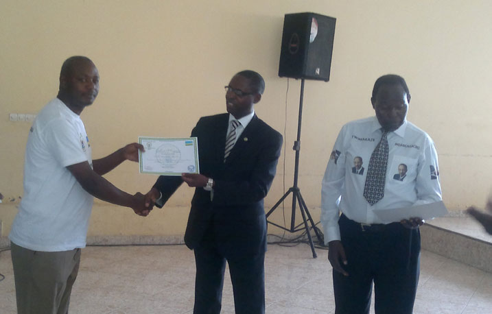 Dr Harebamungu Mathias, umunyamabanga wa Leta ushinzwe amashuri abanza n'ayisumbuye muri Minisiteri y'uburezi, ashyikiriza impamyabumenyi umwe mu batoza b'intore.