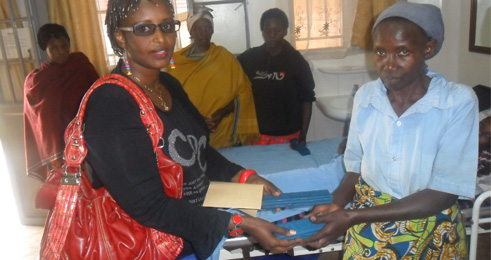 Mme Kaneza ahikiriza impano y'amasabune umwe mu barwayi.