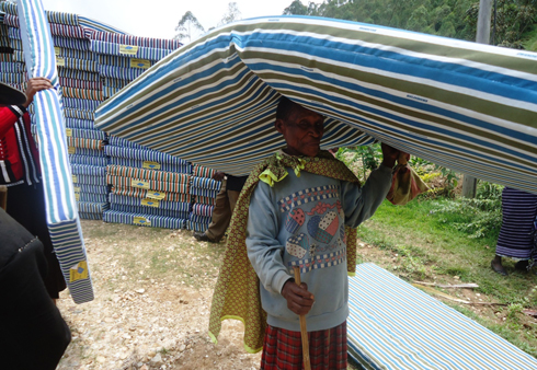 Umwe mu bari mu zabukuru amaze guhabwa matela ye. (Foto: L. Nshimiyimana)