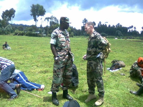 Bodouin aganira n'umusirikare w'umuzungu nyuma yo kugera mu Rwanda ahunze.