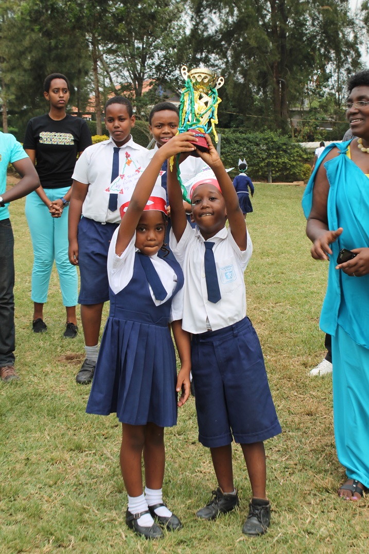 Abana batsinze bishimira igikombe begukanye.