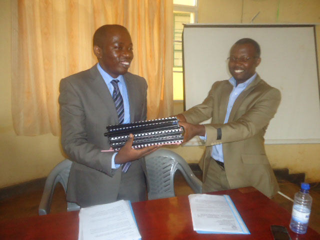 Habiyaremye Pierre Celestin (ibumoso) yakira ibitabo by'inshingano ahawe n'uwari umusimbura w'umunyamabanga nshingwabikorwa w'akarere ka Nyamasheke, Jovith Habyarimana.