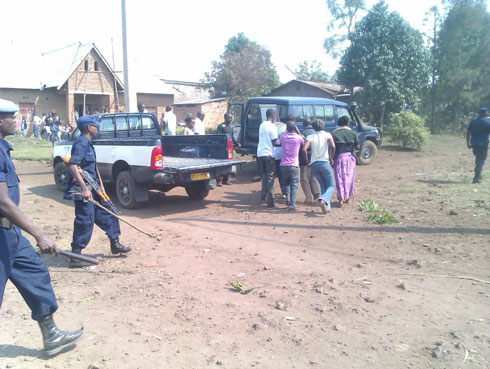 Abantu bari gushyira uwakomeretse mu modoka ya polisi yari itabaye.