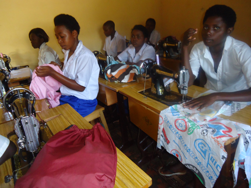 Bamwe mu bagore bacikirije amashuri bigishwa kudoda.