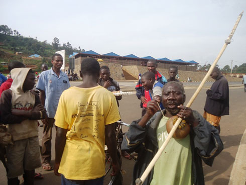 Iyo arimo gucuranga, hari abakomereza ibikorwa byabo hafi ye ariko bumva uko acuranga umuduri. Reba nk'aho inyuma ye hari abacuruza n'abahaha amagi atetse.