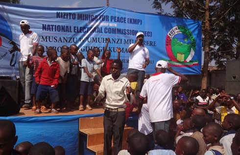 Kizito abana bari bamushageye ubwo yaririmbaga.