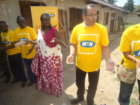 Umuyobozi wa MTN Rwanda n'umuyobozi wungirije w'akarere ka Ruhango bahererekanya amatafari n'abakozi ba MTN.