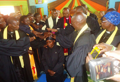 Pasitoro Edith Mukayiranga, umugore umwe rukumbi wahawe ubupasitoro, aha araramburirwaho ibiganza.