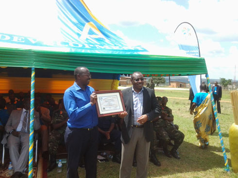 Minisitiri Gatete Claver ashyikiriza ishimwe umucuruzi Budeyi wo mu karere ka Kayonza.