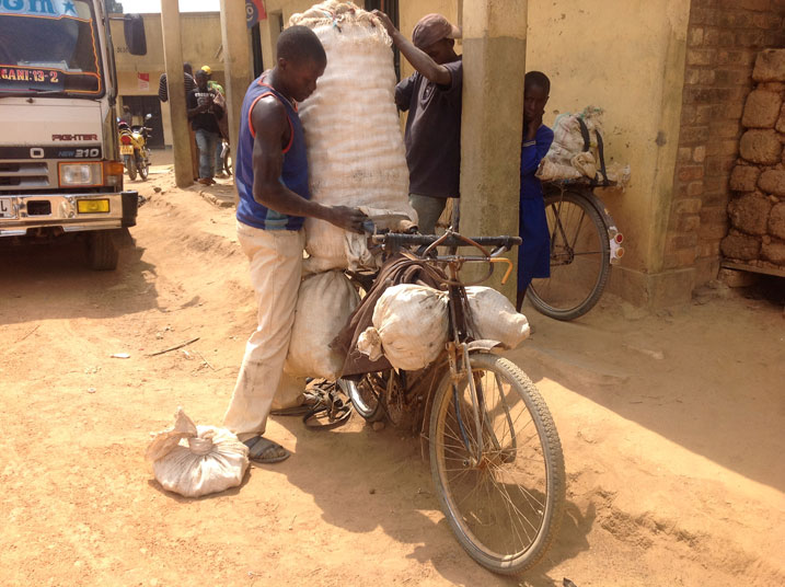 Munyemana Gregoire ari gupakira ibirayi ku igare.