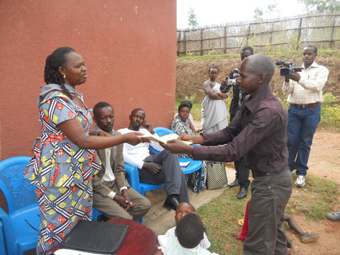 Umukozi wa komisiyo y'igihugu ishinzwe abana ashyikiriza abana birera bo mu mudugudu wa Nyamugari inkunga.