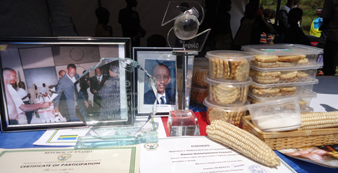 Muri iyi foto, Perezida Kagame aragaragara areba ibikorwa bya Nshimiyimana, ubwo Imbuto Foundation yamuhaga igikombe. Iruhande hariho ibisuguti bikorwa na Cellino Ltd. 