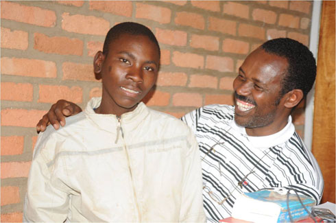 Padiri Murenzi Eugene ari kumwe n'umwana utavuga (Photo: Orinfor)