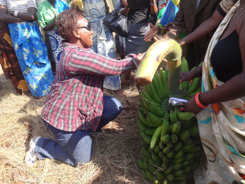 Pamela Mkwamba uhagarariye Delegation ya Malawi bamuha impano agashimira mu muco w'ibabo apfukamye.