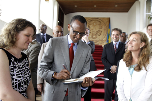 Perezida Kagame asinyira abashyitsi mu gitabo kivuga ku Rwanda cyanditswe n