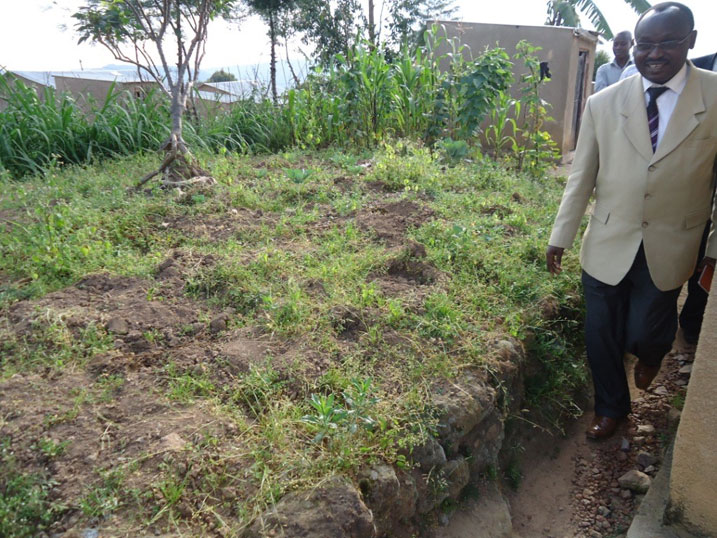 Senateri Sindikubwabo Nepomuscene areba ahaba hahinze akarima k'igikoni yahebye.