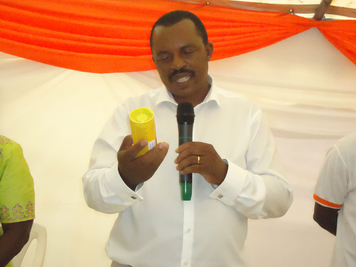 Sina Gerard, umuyobozi wa Entreprise Urwibutso, yereka kimwe mu bicuruzwa bye.