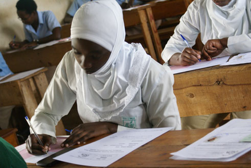 Buri munyeshuri akora ikizamiini cye yicaye wenyine aho yisanzuye kandi atanabasha kugira abo arebaho hafi ye.