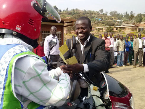 Umucungamutungo wa COPEC Inkunga, Nsengimana Claudien, ashyikiriza umumotari ibyangombwa n'imfunguzo bya moto.