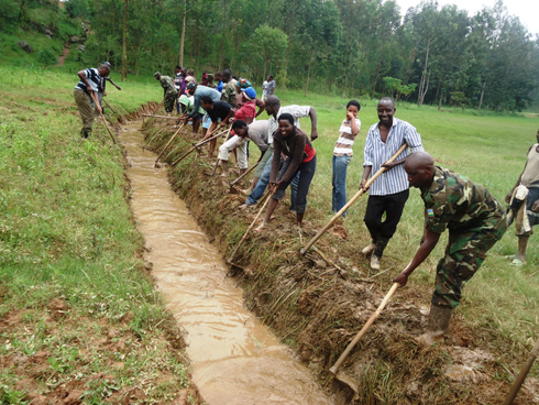 Umuganda wibanze mu gusibura uduferege tubuza amazi kwinjira mu kibuga. (Photo: N. Leonard)
