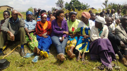 Umukozi w'ikigo cy'igihugu gishinzwe abinjira n'abasohoka (hagati) aganira n'Abanyabisesero.
