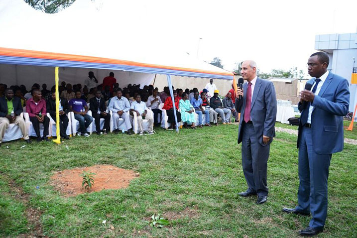 Umuyobozi Mukuru wungirije wa COGEBANQUE yaganiraga n'abakiliya b'iyi banki bari baje kwishimira gutaha inyubako yayo.