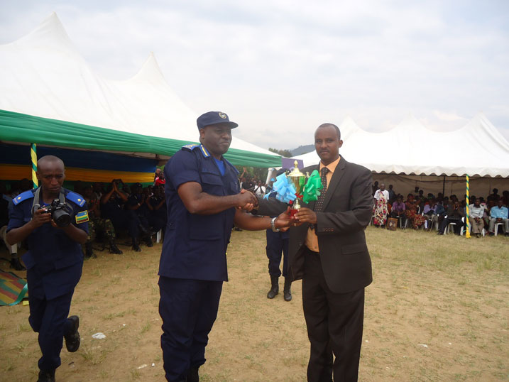 Umuyobozi w'Akarere ka Karongi, Kayumba Bernard, ashyikiriza umukuru wa Polisi y'Igihugu, IGP Emmanuel Gasana, igikombe cy'ishimwe.