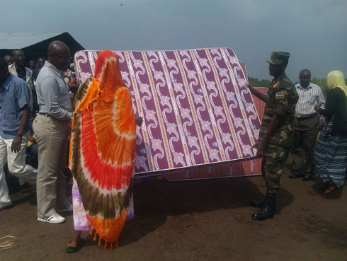 Umuyobozi w'akarere ka Rubavu na Maj.Gen. Mubaraka bashyikiriza Umunyarwanda wirukanwe muri Tanzaniya matela.