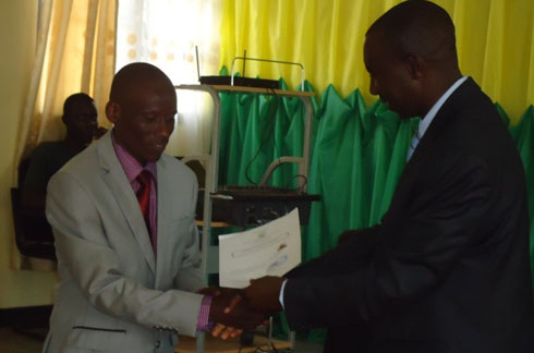 Umuyobozi w'akarere ka Ruhango, Mbabazi Francois Xavier, ashyikiriza Manirakiza icyemezo cyo kuba Umunyarwanda.