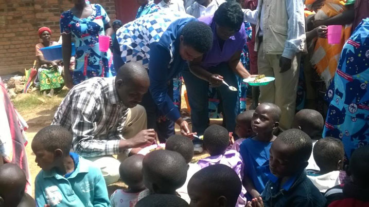 Umuyobozi w'akarere ka Rutsiro, Minisitiri Gasinzigwa (hagati), na Guverineri w'Uburengerazuba bagaburiye abana indyo yuzuye bagamije kwereka ababyeyi uko bagomba kwita ku bana babo.