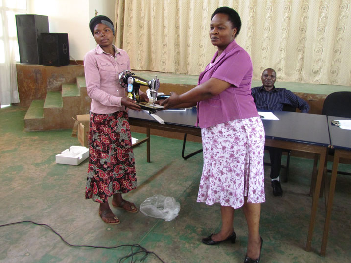 Umuyobozi w'akarere wungirije Madam Odette Uwitonze ashikiriza imashini yo kudoda Joseline Abihoyiki.