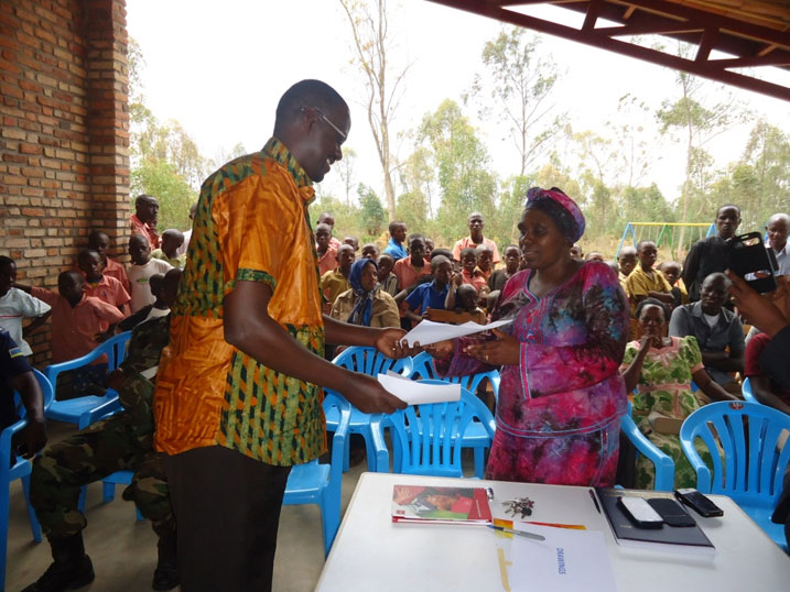 Umuyobozi w'akarere wungirije n'uhagarariye plan international Rwanda bahererekanya ibyakozwe mu nyandiko.